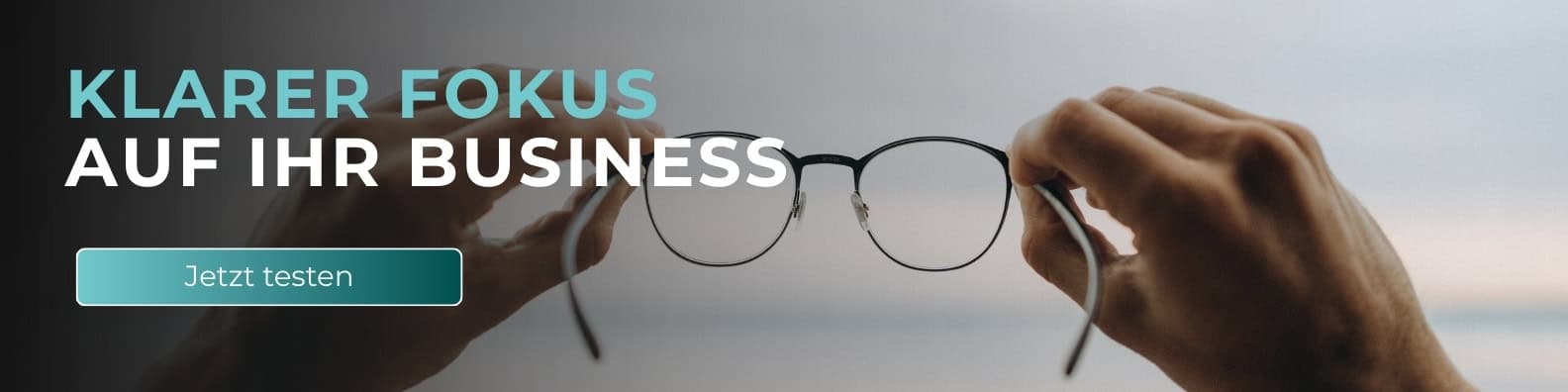 Breites Website-Banner mit der Überschrift „Klarer Fokus auf Ihr Business“ und einem „Jetzt testen“-Button, dargestellt mit Händen, die eine Brille halten, als Symbol für klare Sicht, strategische Ausrichtung und datenbasierte Geschäftsentscheidungen.