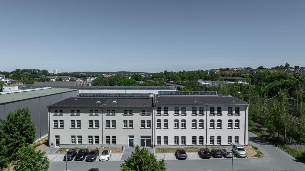Modern office building with solar panels and parking lot in a suburban area